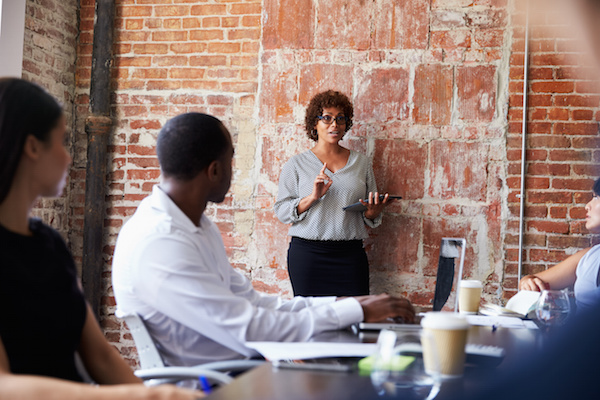 Mature Businesswoman Standing To Address Boardroom Meeting